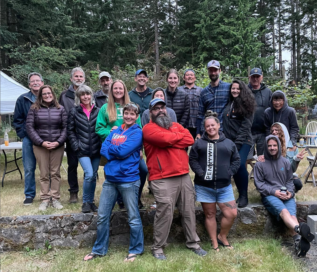 20 volunteers gather casually outside during a chapter meeting 